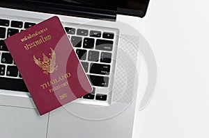 Thailand passport with laptop on white background,