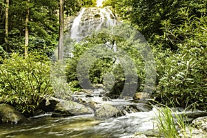 Thailand waterfall in tropical forest. Beautiful nature background. Jungle trees and blue water of mountain river in national par