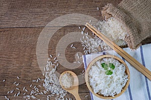 Thailand rice, cooked white rice, cooked plain rice in wooden bowl with spoon and chopsticks, Organic rice on the rustic wooden,