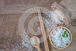 Thailand rice, cooked white rice, cooked plain rice in wooden bowl with spoon and chopsticks, Organic rice on the rustic wooden,