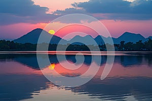 Thailands serene lake reflects vibrant hues of the setting sun