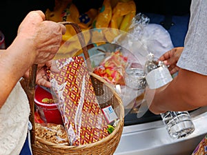 Thais preparing stuff from the back of their car for Rod Nam Dam Hua ceremony, paying respect to the elders