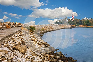 Thangassery Lighthouse on the cliff surrounded by palm trees and big sea waves on the Kollam beach. Kerala, India photo