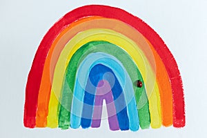 Thank to NHS. Childrens hand drawing rainbow on paper. Greating card for nurses. Ladybug sat photo
