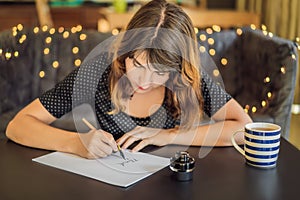 Thank you. Calligrapher Young Woman writes phrase on white paper. Inscribing ornamental decorated letters. Calligraphy