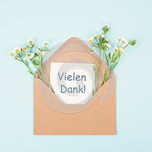 Thank you card in an envelope surrounded by flowers, being thankful, support, help and charity concept, positive attitude