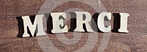 THANK YOU in french MERCI from wooden letter alphabet in the sun on a sunny day