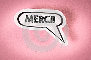 THANK YOU in French. Text on speech bubble. Pink background