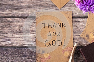 Thank You, God, handwriting on old vintage paper with rustic pen and holy bible book on wooden background, top view