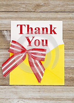 Thank you greeting card with yellow envelope on wood