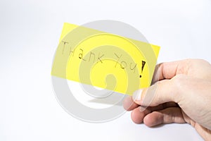 Thank you handwrite with a hand on a yellow paper