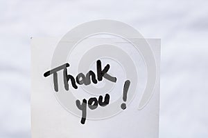 Thank you handwriting text close up isolated on white paper with copy space. Writing text on memo post reminder