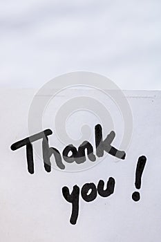 Thank you handwriting text close up isolated on white paper with copy space. Writing text on memo post reminder