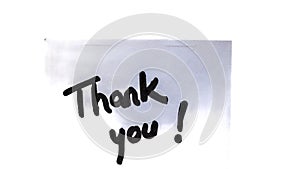 Thank you handwriting text close up isolated on white paper with copy space. Writing text on memo post reminder