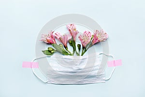 Thank You heroes Doctor and Nurses concept with medical mask and pink flowers on blue background