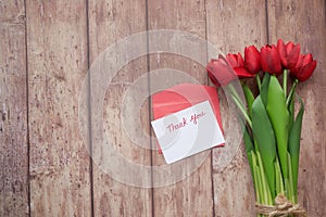 thank you message, envelope and red tulip flower on wooden background