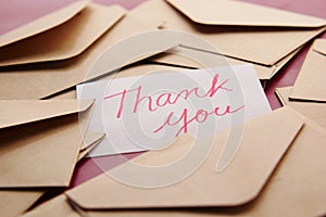 thank you message and envelope on wooden table