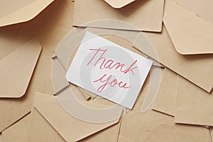 thank you message and envelope on wooden table