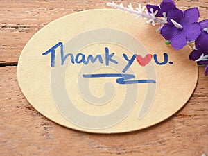 The thank you message is handwritten on a brown oval paper decorated.