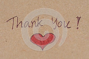 Thank you message with red heart on brown paper.ful concep