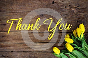 Thank You Message, Yellow tulips on wooden background. Spring flower background with blooming tulips, mockup template.