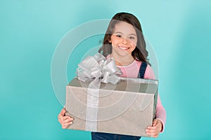 Thank you so much. Child happy face holds big gift box turquoise background. Kid girl delighted gift. Girl curly