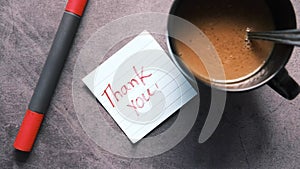 thank you note and coffee mug on table