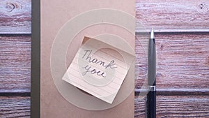 Thank you note and pen on table