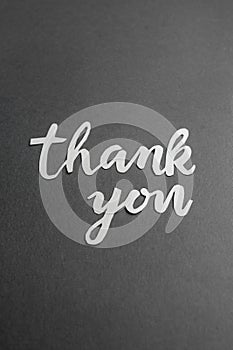 Thank You Paper Cutout on Dark Grey Background. Vertical. Copy space