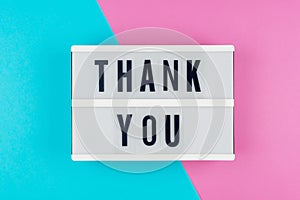 Thank you - text on a display lightbox on blue and pink bright b