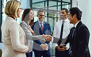 Thank you for welcoming me so warmly to the team. businesspeople shaking hands in an office.