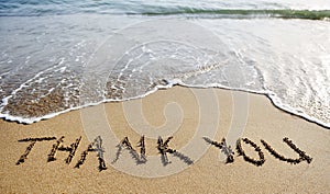 Thank you word drawn on the beach sand