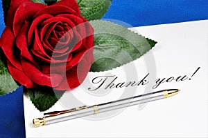Thank you word on a piece of paper and gift a red rose. Thank you â€” the Polite word for it, expresses gratitude, satisfaction, a