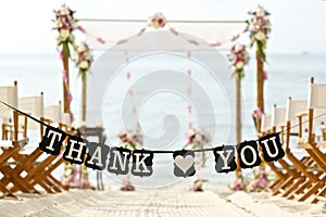 Thank you words banner at beautiful beach wedding set up chairs