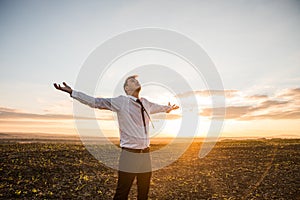 Thankful Businessman with Open Arms at the Field