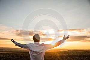 Thankful Businessman with Open Arms at the Field on sunset