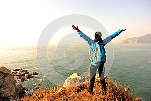 Thankful hiking woman seaside