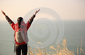 Thankful hiking woman seaside