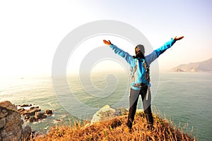 Thankful hiking woman seaside