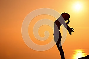 Thankful woman open arms to the sunrise