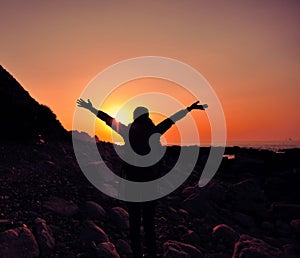 Thankful woman open arms to the sunrise