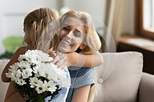 Thankful young blonde mother cuddling little daughter.