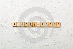 Thankfulness word written on wood block. Thankfulness text on cement table for your desing, concept photo