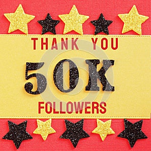 Thanks 50K, 50000 followers. message with black shiny numbers on red and gold background with black and golden shiny stars