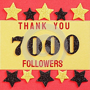 Thanks 7000, 7K, followers. message with black shiny numbers on red and gold background with black and golden shiny stars