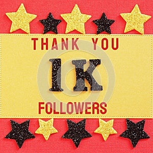 Thanks 1000, 1K followers. message with black shiny numbers on red and gold background with black and golden shiny stars photo