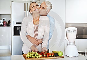 Thanks for taking care of us. Cropped shot of a handsome mature man embracing his wife while she prepares a healthy meal