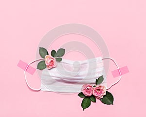 Thanks to Doctor and Nurses concept with medical mask and roses flowers on pink background with copy space