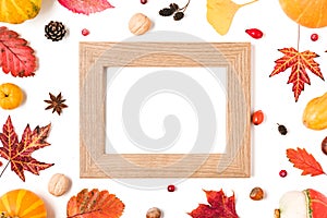 Thanksgiving or autumn background. Fall composition with fallen leaves, dry flowers, berries, nuts and blank photo frame