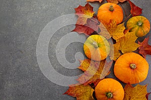 Thanksgiving or Autumnal holiday background, top view, copy space. holiday composition with pumpkins, autumn leaves.